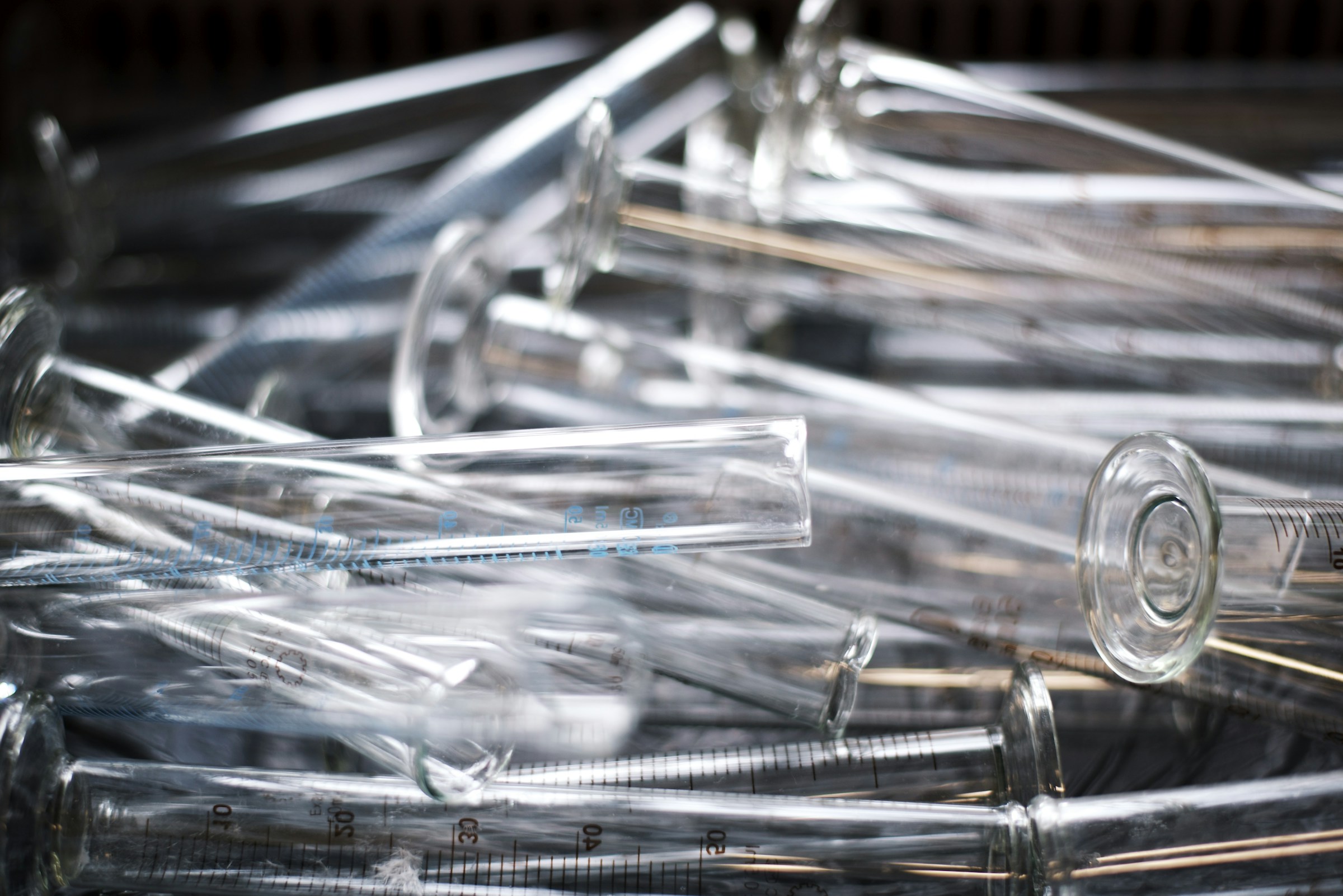 Clear glass measuring cylinders piled in a laboratory