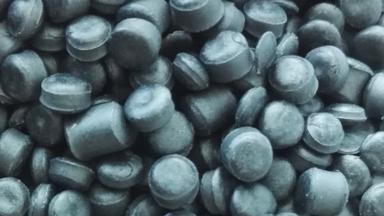 Close-up of dark grey plastic resin pellets. Photo: Teemeah via Wikimedia Commons, CC BY-SA 3.0 (cropped)