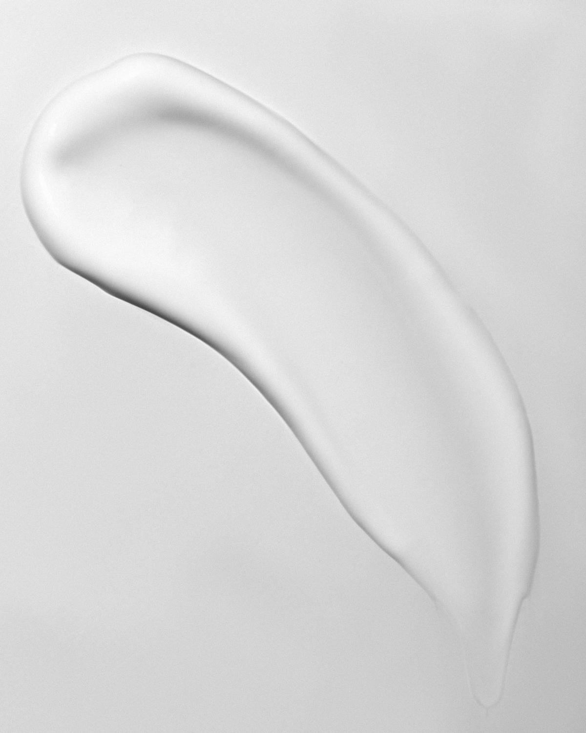 Smear of white skincare cream on a plain white surface. Photo: Jana Kukebal on Pexels