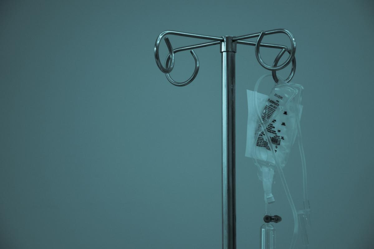 IV fluid bag hanging from a stainless steel infusion stand. Photo: Marcelo Leal on Unsplash