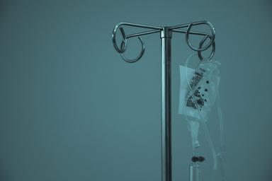IV fluid bag hanging from a stainless steel infusion stand. Photo: Marcelo Leal on Unsplash