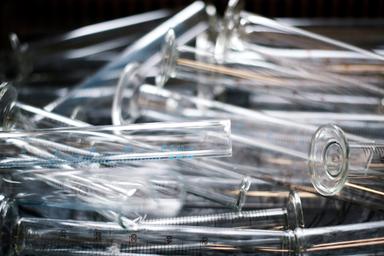 Clear glass measuring cylinders piled in a laboratory