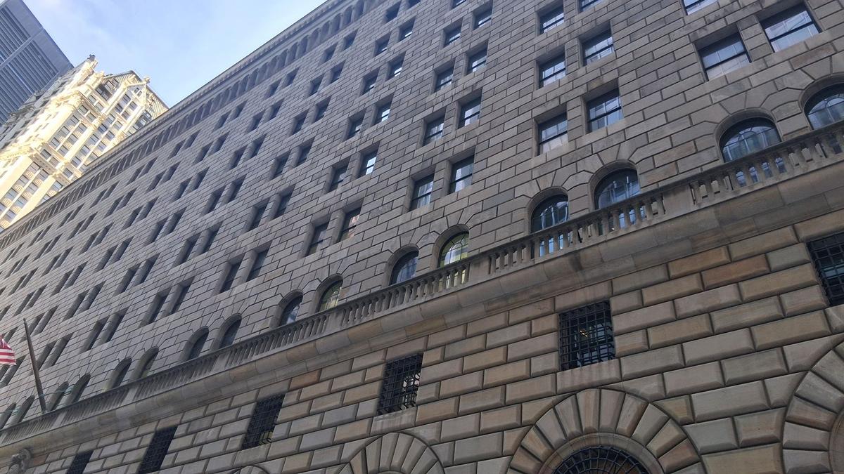 Upward view of the limestone facade and arched windows of the Federal Reserve Bank of New York building. Photo: Kidfly182 via Wikimedia Commons, CC BY 4.0