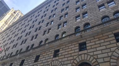 Upward view of the limestone facade and arched windows of the Federal Reserve Bank of New York building. Photo: Kidfly182 via Wikimedia Commons, CC BY 4.0