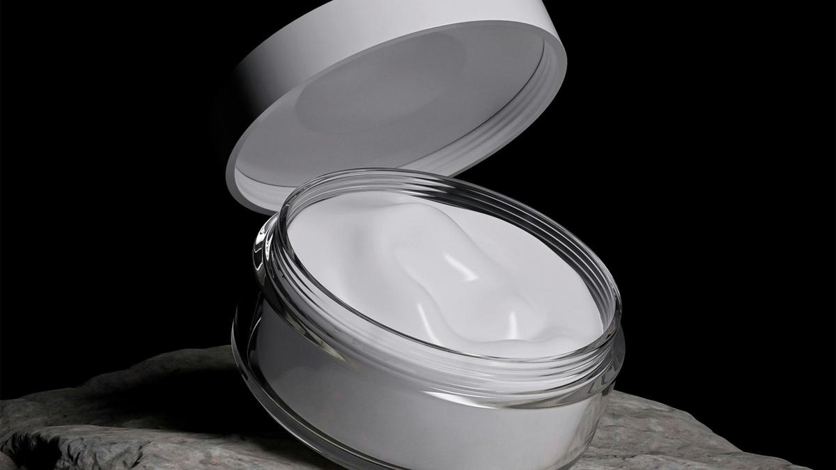 An open jar of white cream on a rock against a black background. Photo by Eveling Salazar on Unsplash.