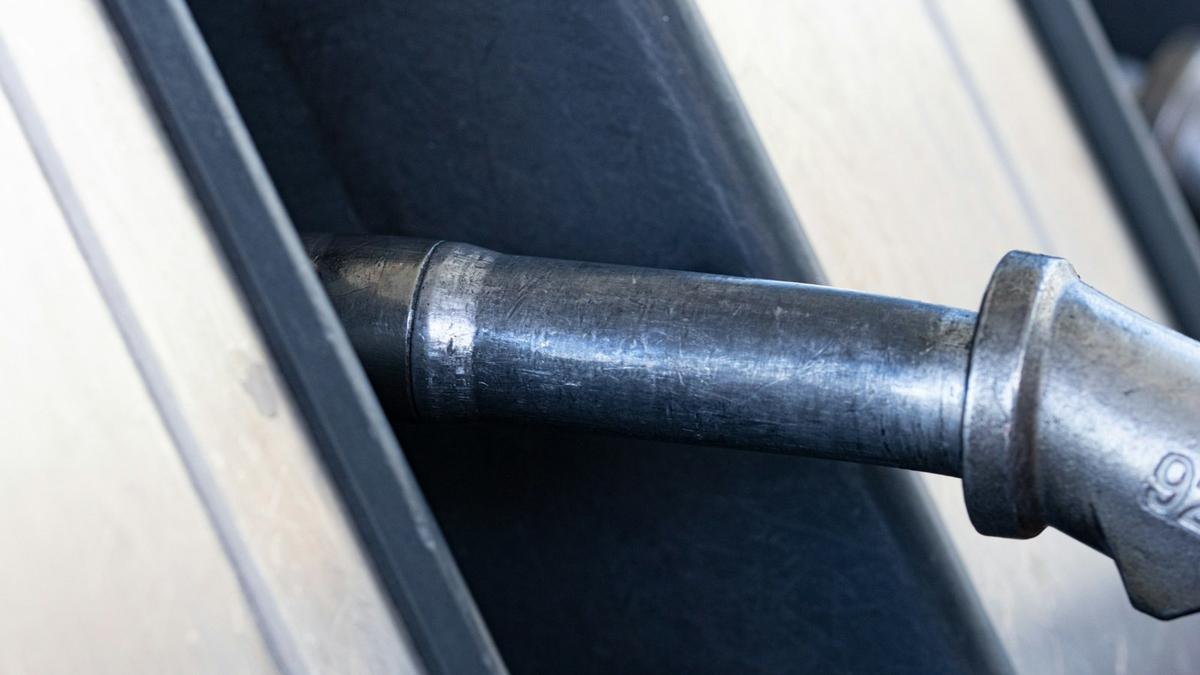 A close-up of a gas pump nozzle in a car's fuel filler. Photo: Marek Studzinski on Unsplash.