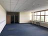 Empty office room with blue carpet and wood-framed windows. Photo: Np6824 / Wikimedia Commons, CC BY-SA 4.0