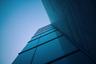 Corner of a glass office building seen from below against a blue sky. Photo: Jonathan Simcoe / Wikimedia Commons, CC0